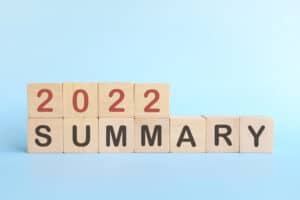 iStock 1428285389 Year end 2022 review and summary concept. Wooden blocks in blue background.